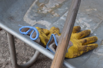Schmutzige Gartenhandschuhe gelb in Schubkarre aus Metall für die Gartenarbeit