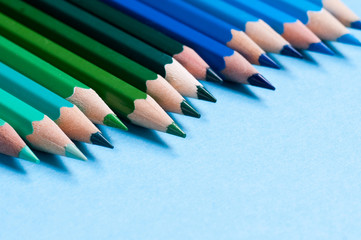 Color pencils isolated on blue background.
