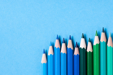 Color pencils isolated on blue background.
