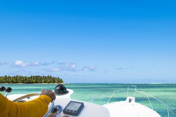Hand of captain on steering wheel of motor boat in the blue ocean during the fishery day. Success...