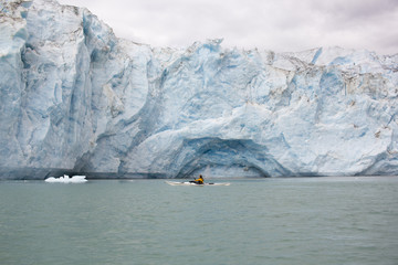 Woman kayaking in front of McBride glacier in Glacier Bay National Park, Alaska, USA
