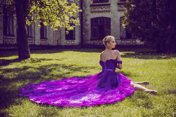 Fototapeta premium Young Ballerina in vintage look. Ballet Dancer Girl. Image of a Dancing Woman. Lady in purple evening dress demonstrated femininity. Classical Choreography Style 