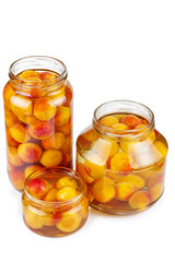 Apricots canned in glass jars isolated on white background