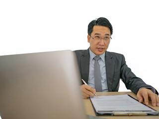 Happy asian business man sitting on his desk on isolated background