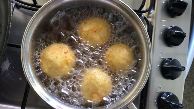 Frying rice balls stuffed with cheese filling, traditional French boulette de riz