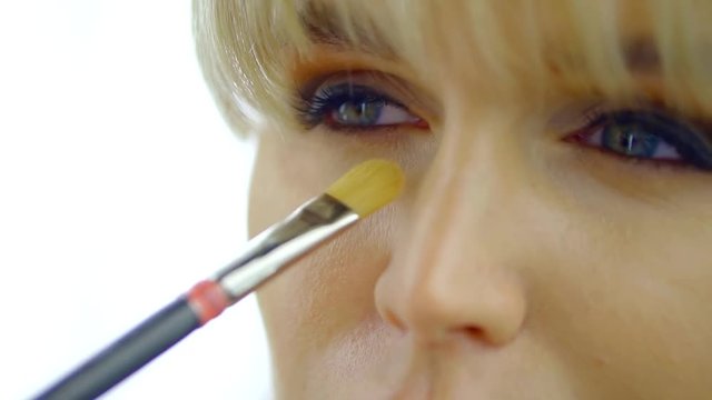 Eye makeup woman applying eyeshadow powder. Beautiful female face. The perfect makeup. Fashion beauty.