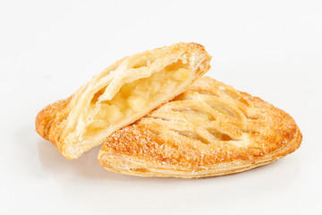 Tasty puff pastry dessert cut in half . Delicious pastries with fruit jam on light background. berry, apples, pear