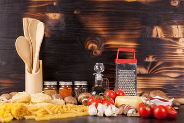 Healthy and delicous meal - raw uncooked pasta next to vegetables on rustic vintage wooden background