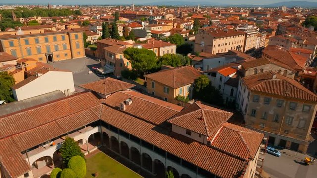Aerial establishing shot of the beautiful Pisa Old Town and Tuscan scenery, including the Opera del Duomo Museum, Italy. Pisa has more than 20 historic churches and several medieval palaces