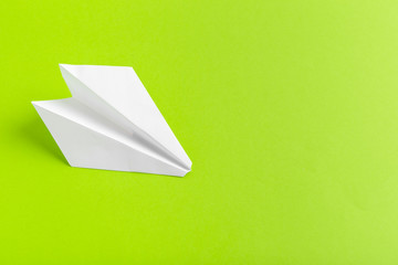 Flat lay of a paper plane on green pastel color background