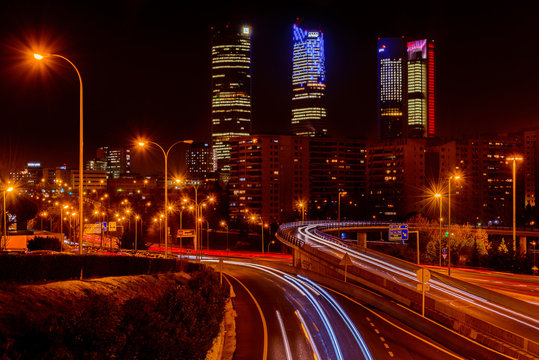 Night long exposure photography at M30 highway with Madrid skyline (Four towers business area) as background, Spain