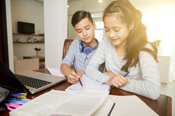 Mixed-race teenage boy explaining homework to his sister
