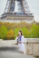 Woman in white dress near the Eiffel tower in Paris, France