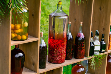 Tincture bottles of lemon, currant, berries and rowanberries. Herbal medicine. Spirits, wine and...