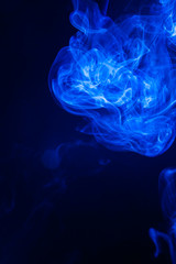 Blue smoke on black background.
