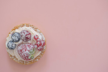 cakes with berries on pink background