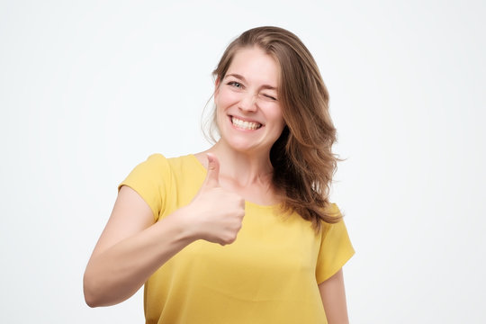 Happy Young Woman Giving Thumbs Up On White Background