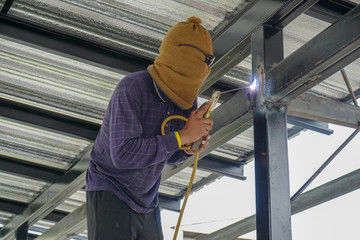 Fototapeta premium Welders are welding steel roof frame of home