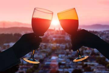Hands of female's and male's with glass of wine on San Francisco city background. Service on the...