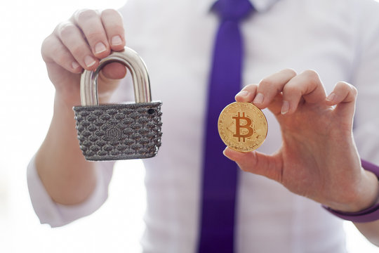 Business woman offers a gold crypto currency bitcoin and vintage padlock. Ddigital financial technology background. Template for text and icons. Secure fintech.