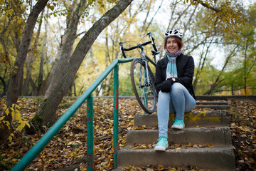 Obraz na płótnie Canvas Photo of brunette sitting on stairs next to bicycle