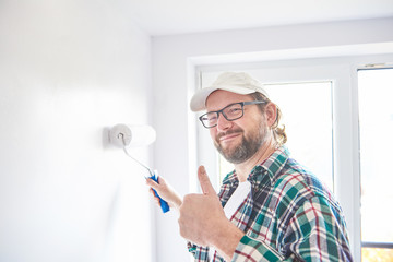 Man painting wall in white colour