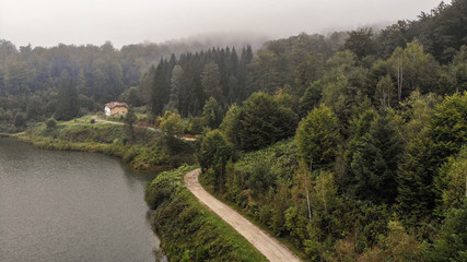 Aerial view of lake on mountain Goc in the fog. First signs of autumn, yellow ends on leaves. Mountain Goc - Serbia.