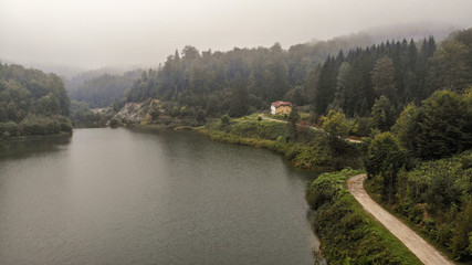 Aerial view of lake on mountain Goc in the fog. First signs of autumn, yellow ends on leaves. Mountain Goc - Serbia.