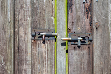 Old wooden door with two rusted metalic locks