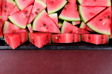 Pattern of watermelon slices. Pieces of ripe watermelon in old metal dishes. Red fruit with...