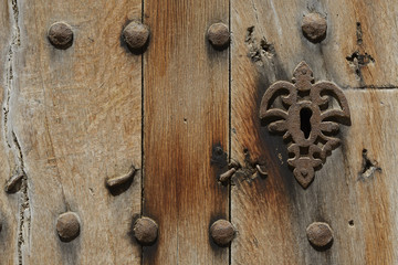 Alte Holztür mit rostigen Nägeln und rostigem Schloss