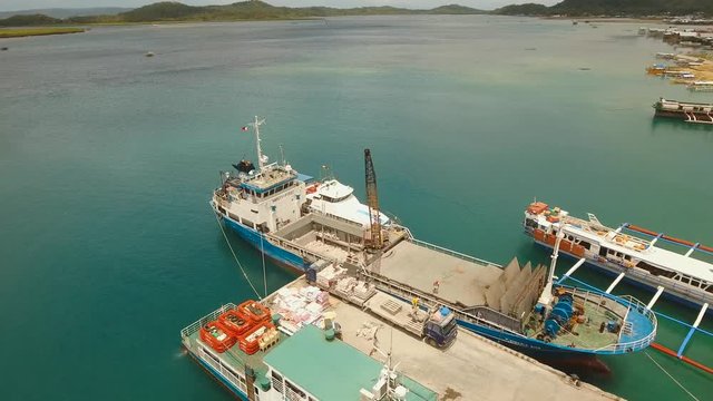 aerial footage cargo and passenger port with barges and cargo ships Dapa city, Siargao, Philippines. passenger ferry terminal
