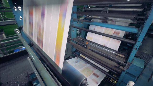 Newspaper moving on a printing conveyor, close up.