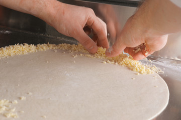 Hands of Chef making cheese border of pizza
