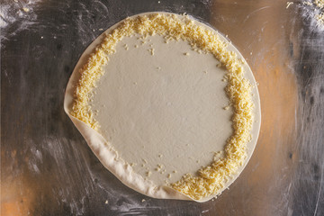Making cheese border of pizza. Top view of filling.