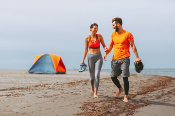 Young couple enjoying the beach after workout