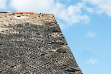 Fototapeta na wymiar Broken leaking asbestos roof