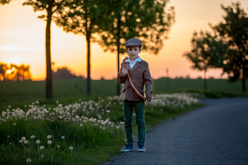 Obraz premium Portrait of child playing with bow and arrows, archery shoots a bow at the target.