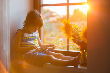 Cute little toddler child, playing with abacus on a window