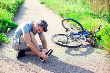 Man with pain in knee joints after biking on bicycle. Sport, healthcare and people concept