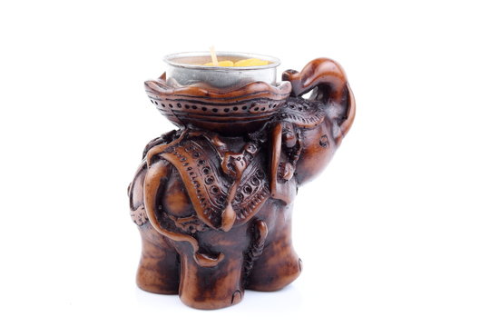 Brown elephant made of resin like wooden carving with candle holder with white ivory. Stand on white background, Isolated, Art Model Thai Crafts, For decoration Like in the spa.