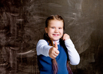  schoolgirl against chalkboard, with her thumb up