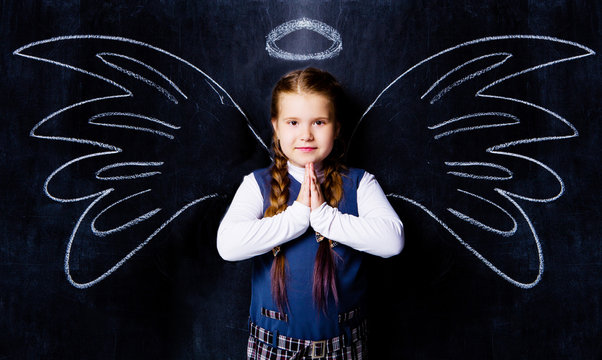  schoolgirl against chalkboard, with drawn angel wings