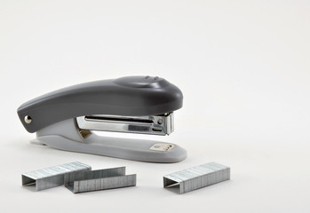 Stationery stapler and metal staples on white background.