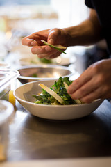 Chef plating fresh ricotta gnocchi in an Italian restaurant.