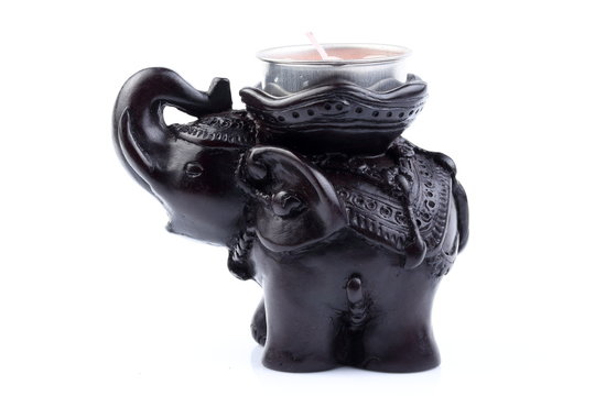 Black elephant made of resin like wooden carving with candle holder with white ivory. Stand on white background, Isolated, Art Model Thai Crafts, For decoration Like in the spa.