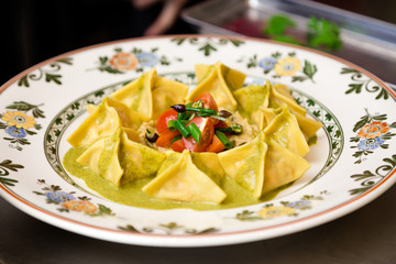 Plate of fresh ravioli in a pesto sauce..