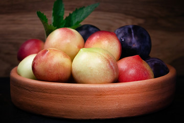 pulms and nectarines on clay plate