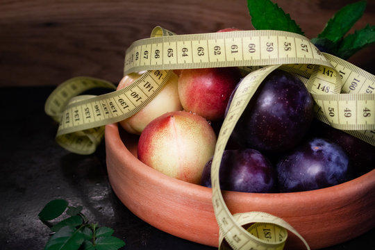 pulms and nectarines on clay plate with tape masure