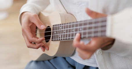 Fototapeta na wymiar Woman play ukulele at home